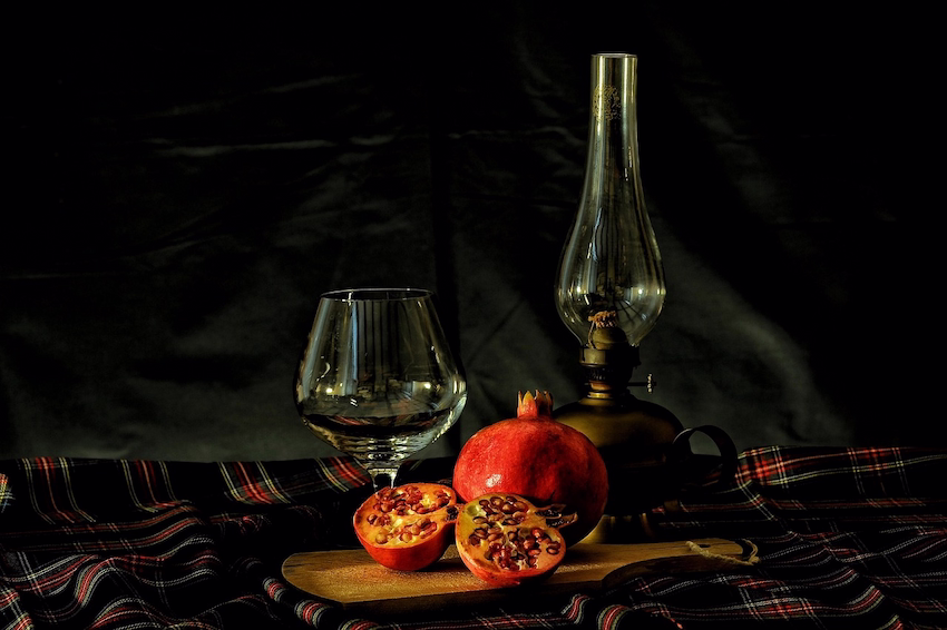 Deep lamp with a red pomegranate extract on a wine bottle in daylight